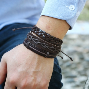 Close-up of vintage multilayer braided leather bracelet set with cross-stitched textures