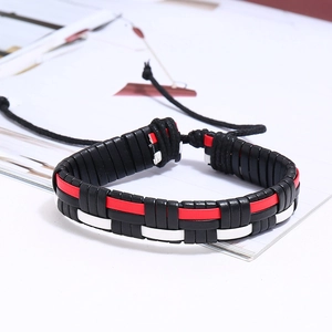 Détail d'un bracelet en cuir tressé tricolore avec cordon de serrage noir ajustable