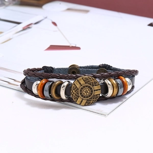 Detail of multi-layer vintage punk bracelet with braided leather, wood beads, and metal charms