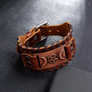 Gros plan du bracelet en cuir vintage avec plaque en bronze pentagramme et bords tressés