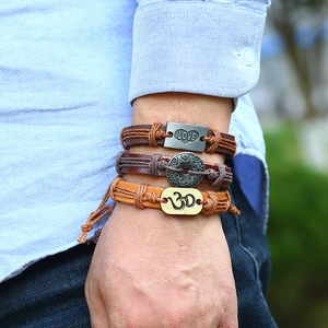 Close-up of vintage braided leather bracelets with LOVE and Om symbol metal charms