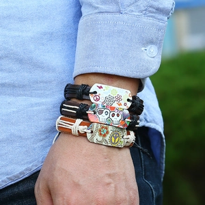 Close-up of three-piece bohemian leather bracelets with printed charms on a male wrist