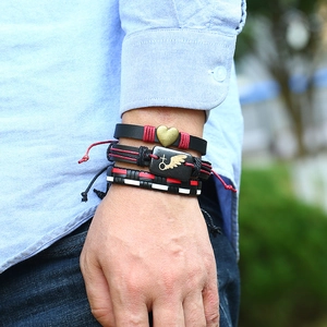 Gros plan de bracelets punk vintage en cuir avec breloques ailes en métal et croix