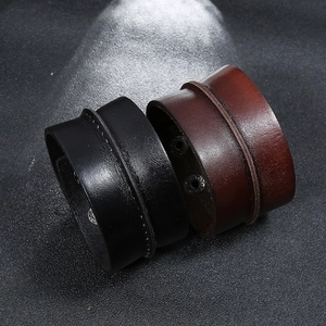 Detail of wide punk leather bracelets in black and dark brown with metal rivet buttons