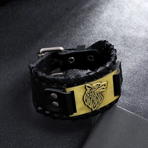 Macro detail of Nordic Viking leather bracelet featuring embossed Celtic wolf head and bronze buckle