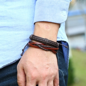 Close-up of vintage multi-layer braided leather bracelets worn on wrist with adjustable knot