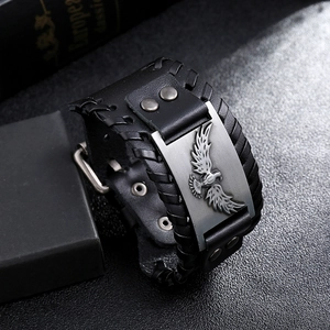 Dettaglio del bracciale vichingo in pelle nera con placca aquila d'argento e bordi intrecciati