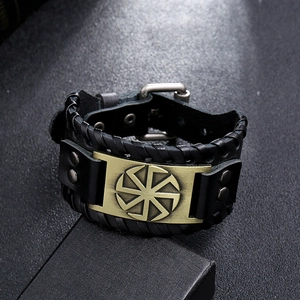 Macro shot of punk leather bracelet with bronze Kolovrat sun wheel symbol and rivets