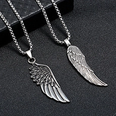 Détail des pendentifs d'ailes vintage en argent vieilli avec texture de plumes