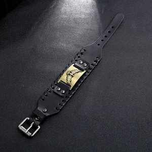 Dettaglio del bracciale vintage in pelle intrecciata nera con placca in metallo aquila
