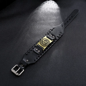 Détail d'un bracelet en cuir noir vintage avec symbole Om et bordure tressée