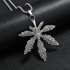 Vue macro du pendentif feuille de cannabis en acier argenté avec texture détaillée