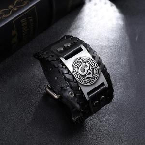 Détail du bracelet vintage en cuir tressé noir avec symbole Om et rivets métalliques