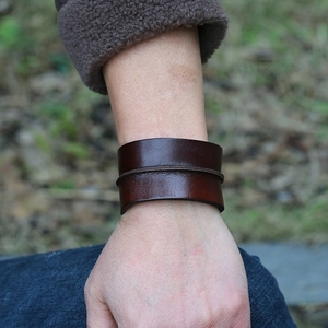 Men's wide retro brown leather punk bracelet featuring a raised spine on a male wrist