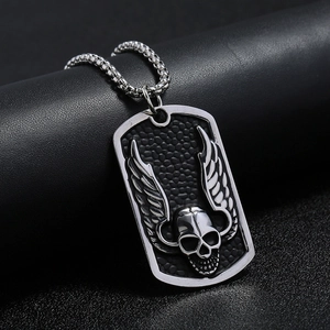 Macro detail of punk skull pendant with wings and black frosted texture on steel chain