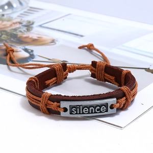 Close-up of vintage braided leather bracelet featuring a silver silence charm and rope