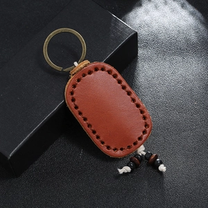 Detailed close-up of handmade double-layer leather keychain with bronze ring and beads