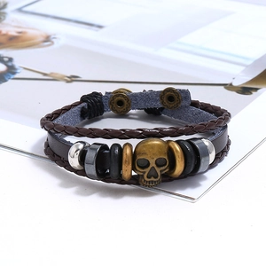 Detail view of multi-layer punk leather bracelets with bronze skull and snap button