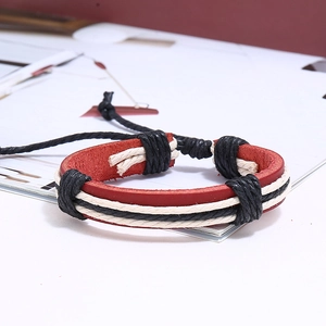 Détail macro d'un bracelet multicouche en cuir tressé rouge noir et blanc élégant