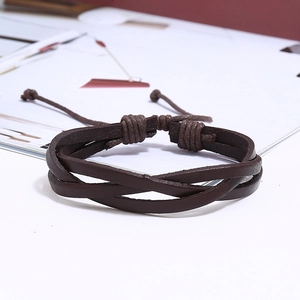 Détail macro du bracelet en cuir tressé multicouche marron foncé avec cordon ajustable