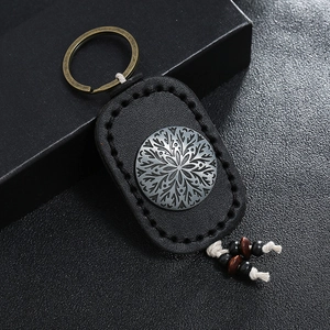 Vintage black leather keychain with engraved metal ornament and wooden beads