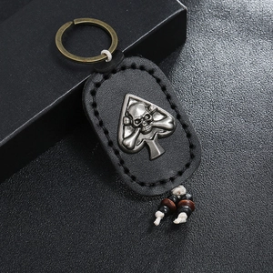 Handmade leather keychain with skull spade metal emblem and ethnic bead tassel pendant