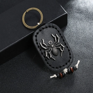 Handmade vintage leather keychain with a detailed silver spider emblem and wooden beads