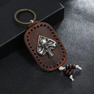 Vintage brown leather keychain with skull spade metal emblem and handmade stitching
