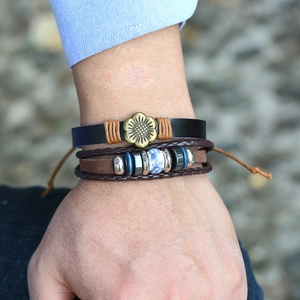 Détail d'un bracelet multicouche en cuir vintage avec charme tournesol et perles
