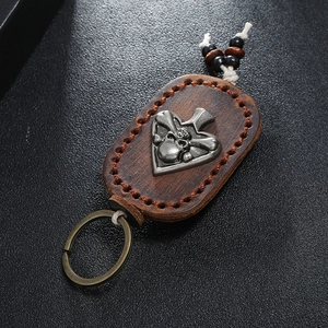 Macro shot of vintage leather keychain with hand-stitched edges and silver skull motif
