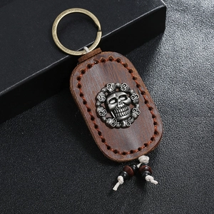 Retro handmade brown leather keychain with silver skull emblem and wood bead details