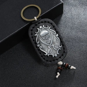 Vintage leather keychain with silver skull emblem and wood bead tassel details