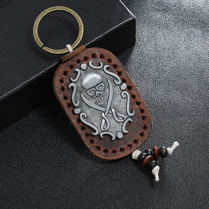 Vintage leather keychain with pirate skull emblem and rustic handmade stitching detail