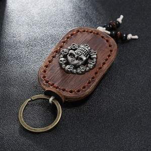Detail of vintage leather keychain with silver skull emblem and hand-stitched edges