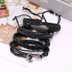 Detail of four-piece black woven leather bracelet set with wing and anchor metal charms