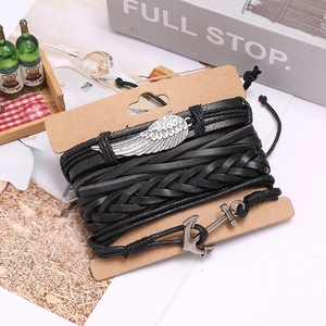 Retro multi-layer black braided leather bracelet set with wing and anchor charms on a card