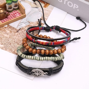 Detail of vintage multilayer leather bracelet set with wooden beads and compass charm