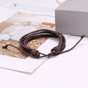 Retro multi-layer dark brown woven leather bracelet with adjustable cord on white background