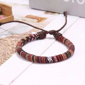 Detail of ethnic woven bracelet featuring red and yellow geometric patterns and adjustable cord