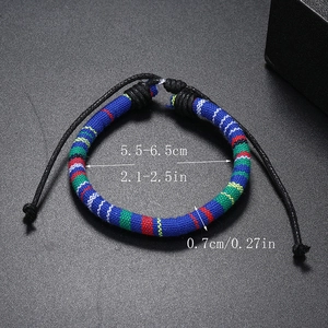 Detail view of woven bohemian bracelet showing dimensions and adjustable knot on black background