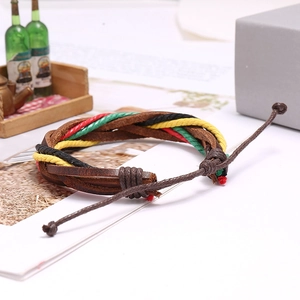 Dettaglio del bracciale in pelle intrecciata a mano con fili colorati e nodo regolabile