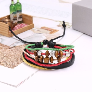 Dettaglio di bracciale intrecciato multistrato con perline di legno e inserti metallici