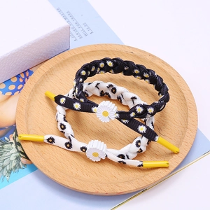 Braided daisy bracelet in black and white with 3D floral charm and knotted cord