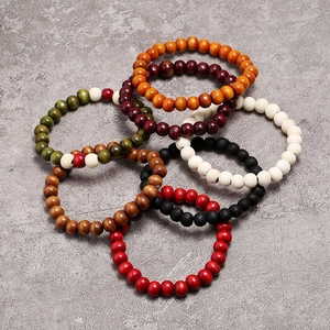 Pulseras de cuentas de madera hechas a mano en varios colores sobre fondo de piedra