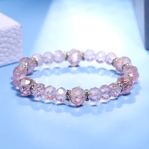 Detalle macro de cuentas de cristal rosa facetado y espaciadores de diamantes plateados