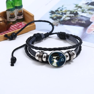 Macro shot of Libra zodiac braided leather bracelet with glow-in-the-dark glass bead