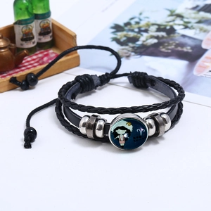 Detail of Aries constellation leather bracelet with woven cords and glass dome charm