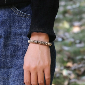Vintage coconut shell beaded bracelet with natural texture on a male model wrist