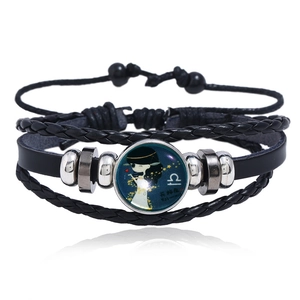 Detail of multi-layer leather bracelet featuring Libra zodiac sign with luminous bead