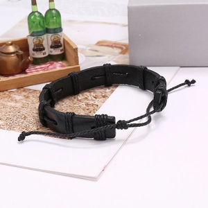 Retro punk black woven leather bracelet with adjustable cord on white reflective surface